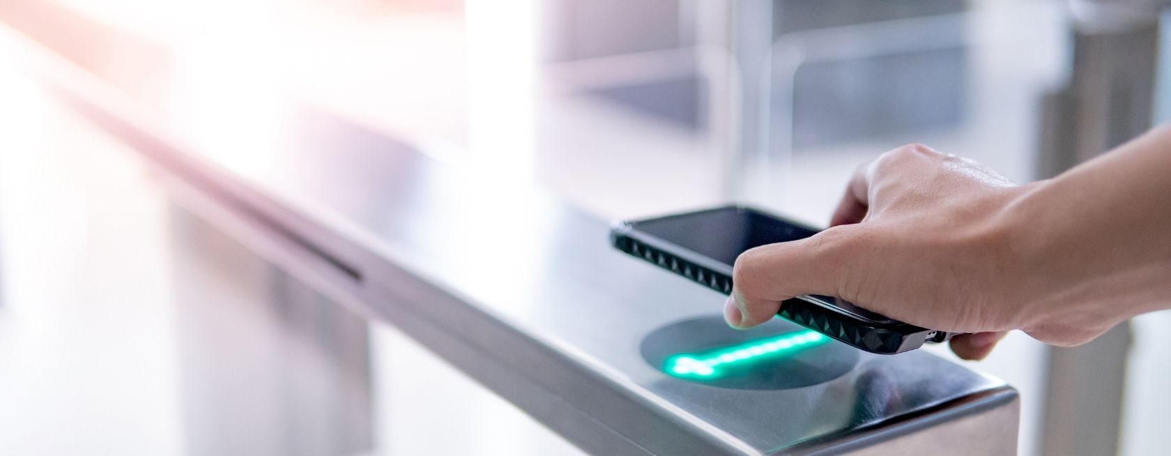 Mano utilizando un smartphone para abrir una puerta automática.